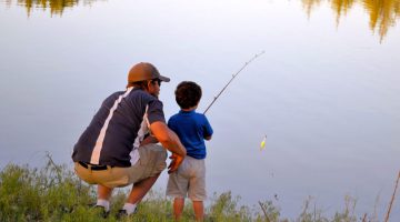 dad and son fishing in lake